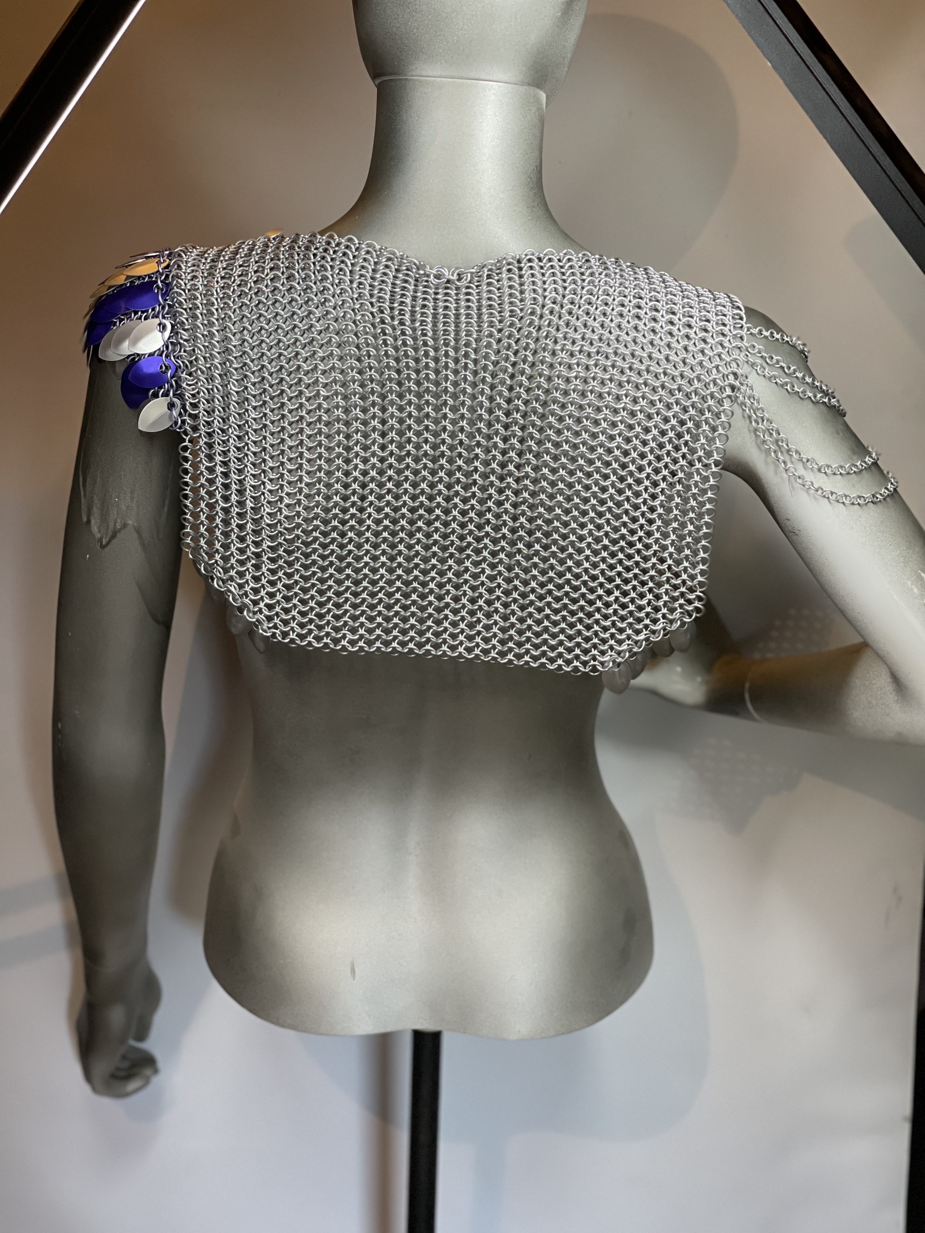 Silver chainmaille armor with dark purple and silver shoulder scales, mythic battle-inspired fantasy design